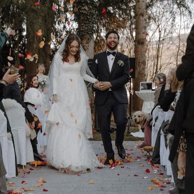 They are holding hands and smiling with people around them clapping.